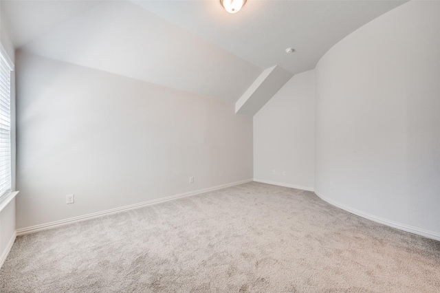 additional living space featuring carpet flooring, baseboards, and lofted ceiling