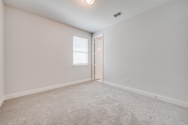 carpeted empty room featuring visible vents and baseboards