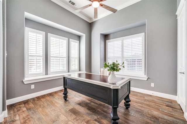 office featuring hardwood / wood-style floors, ornamental molding, baseboards, visible vents, and a ceiling fan