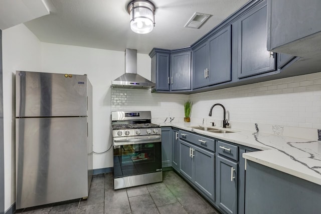 kitchen with visible vents, decorative backsplash, appliances with stainless steel finishes, wall chimney exhaust hood, and a sink