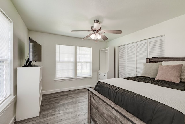 bedroom featuring a closet, a ceiling fan, baseboards, and wood finished floors