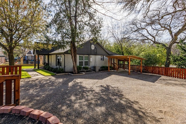 view of side of property with brick siding and fence