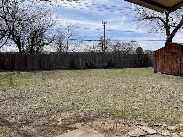 view of yard featuring fence, an outdoor structure, and a shed