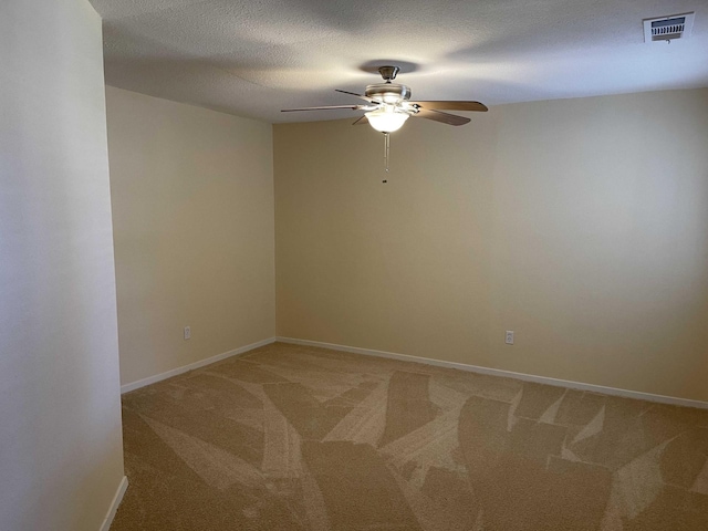 unfurnished room with visible vents, light carpet, a textured ceiling, baseboards, and ceiling fan