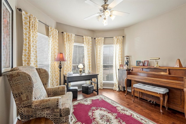 living area with a ceiling fan and wood finished floors