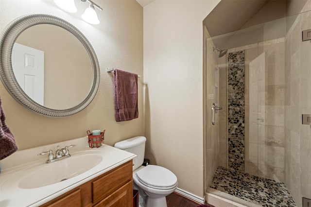 full bathroom featuring a shower stall, toilet, and vanity