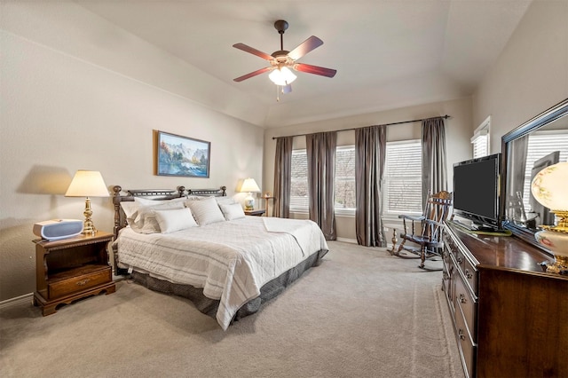 bedroom featuring light colored carpet, a ceiling fan, a tray ceiling, and baseboards