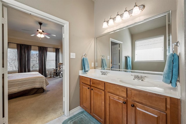 full bathroom with double vanity, ensuite bathroom, a ceiling fan, and a sink