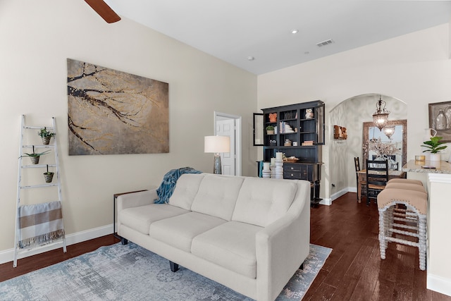 living area with arched walkways, visible vents, baseboards, and hardwood / wood-style floors