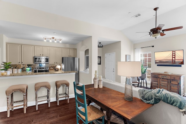 dining area featuring visible vents, dark wood-type flooring, ceiling fan, vaulted ceiling, and arched walkways