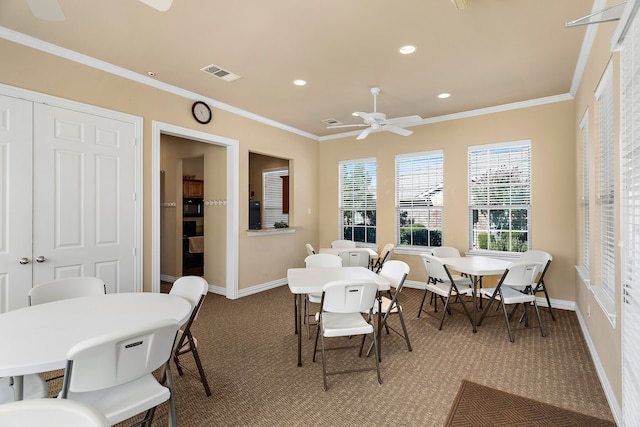 dining room featuring crown molding, a ceiling fan, visible vents, and baseboards