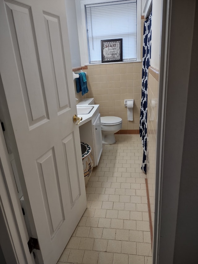 full bathroom featuring a shower with shower curtain, vanity, toilet, and tile walls