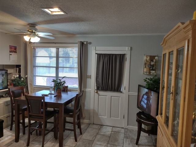 dining space with a textured ceiling, crown molding, and a ceiling fan