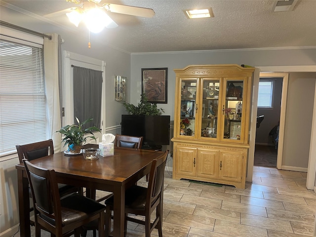dining area featuring a textured ceiling, visible vents, crown molding, ceiling fan, and wood tiled floor