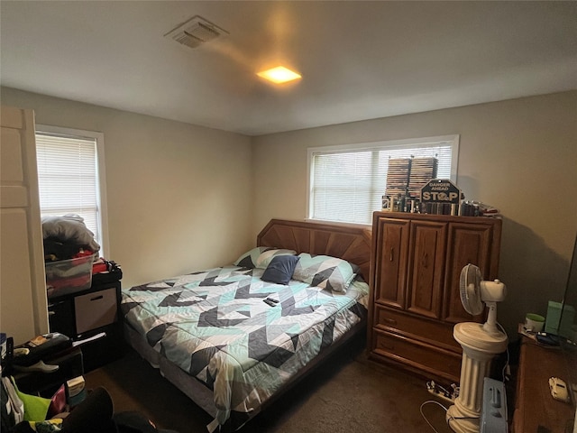 bedroom featuring visible vents and dark carpet