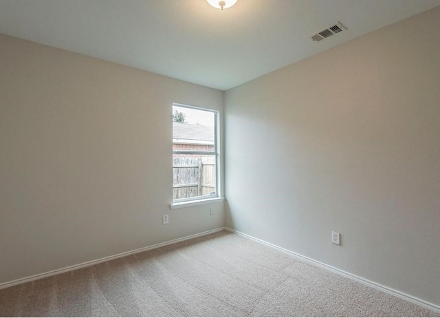 carpeted spare room with baseboards and visible vents