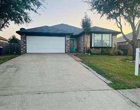 single story home with a front yard, an attached garage, and driveway