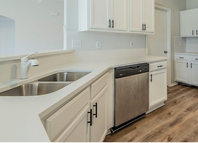 kitchen with dishwasher, light countertops, light wood-style flooring, white cabinetry, and a sink