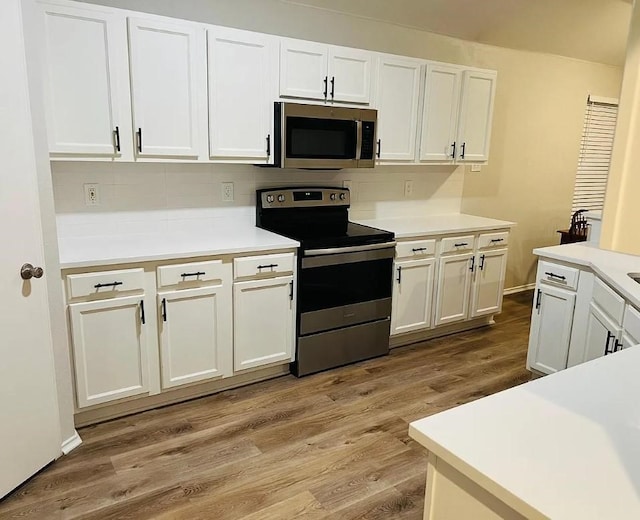 kitchen with light wood-style flooring, white cabinetry, stainless steel appliances, and light countertops