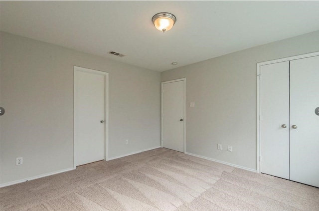 unfurnished bedroom featuring carpet, visible vents, and baseboards