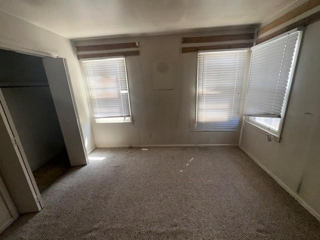 unfurnished bedroom featuring carpet and baseboards
