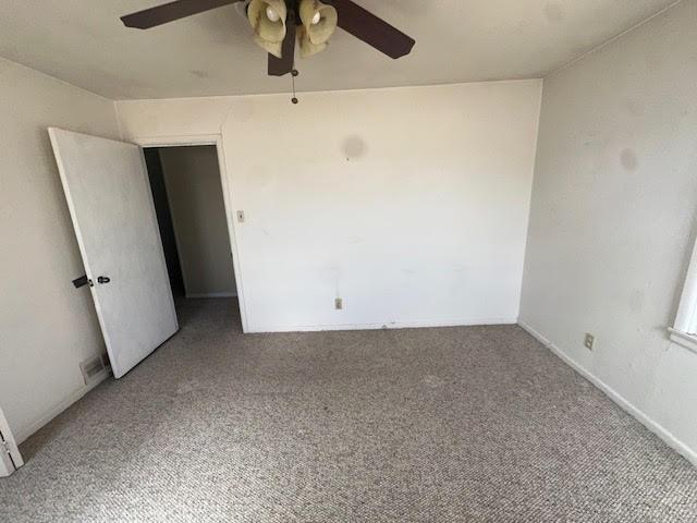 empty room with a ceiling fan and carpet floors