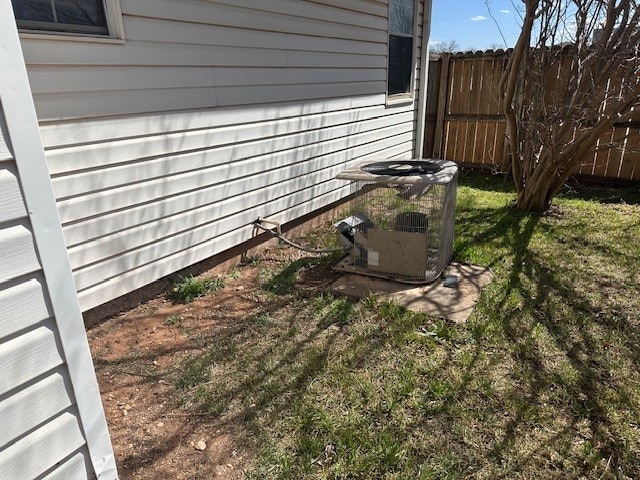 exterior details with central air condition unit and fence