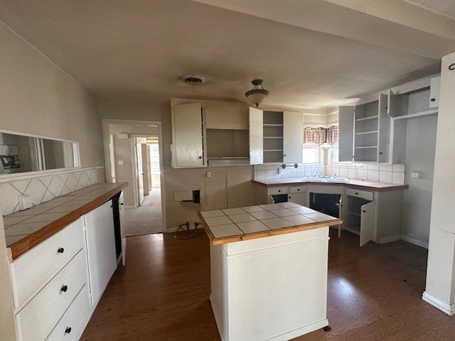 kitchen with open shelves, a center island, tile countertops, decorative backsplash, and dark wood-style flooring