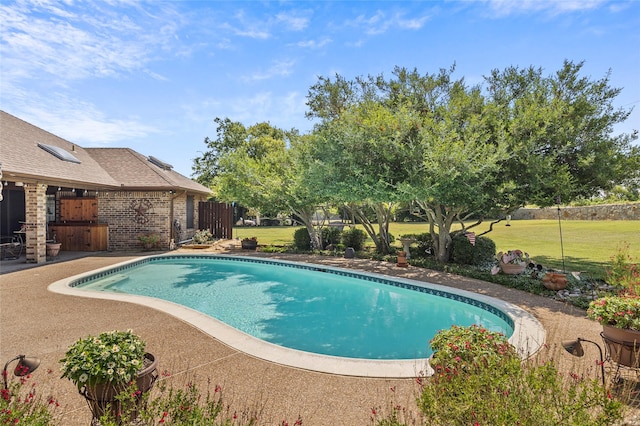 pool featuring a patio area, a lawn, and fence