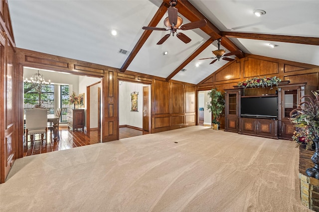 unfurnished living room featuring carpet flooring, visible vents, and wood walls