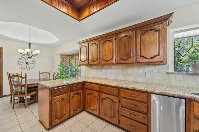 kitchen with light tile patterned floors, decorative backsplash, refrigerator, and a peninsula