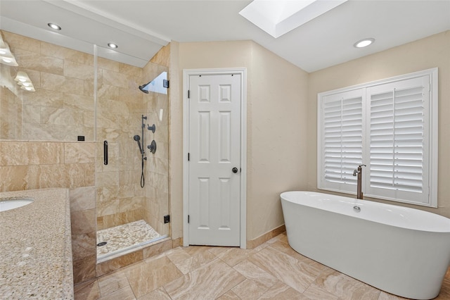 bathroom with a skylight, a freestanding tub, baseboards, and a stall shower