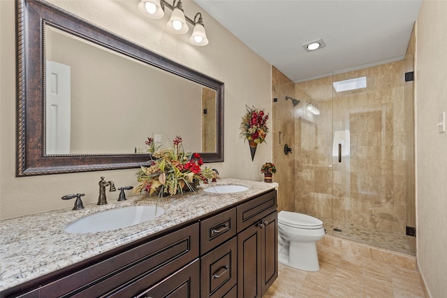 full bathroom with a sink, toilet, a stall shower, and double vanity