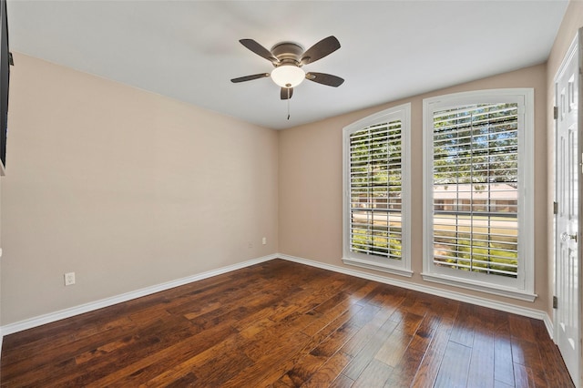 unfurnished room featuring baseboards, dark wood-style flooring, and ceiling fan