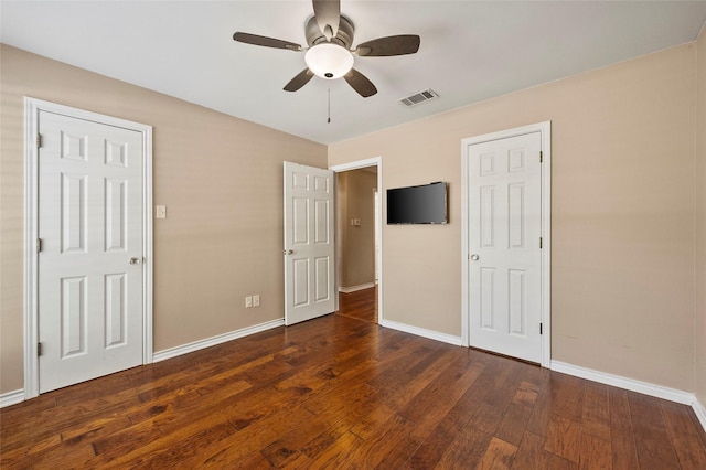 unfurnished bedroom featuring hardwood / wood-style flooring, baseboards, visible vents, and ceiling fan