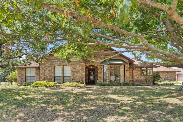 view of front of property featuring a front yard and brick siding