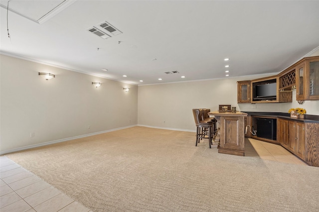 interior space with baseboards, visible vents, ornamental molding, bar area, and light carpet