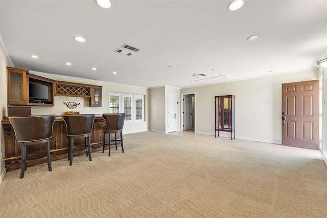 kitchen with recessed lighting, light colored carpet, a breakfast bar, and crown molding