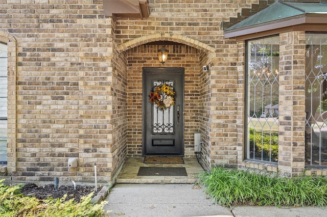 view of exterior entry featuring brick siding