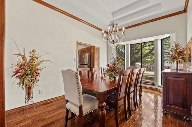 dining room with a tray ceiling, crown molding, dark wood-style flooring, and a chandelier