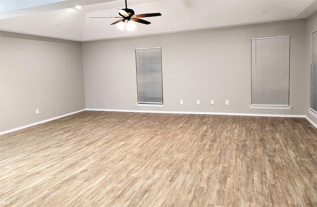 unfurnished room featuring baseboards, wood finished floors, lofted ceiling, and ceiling fan