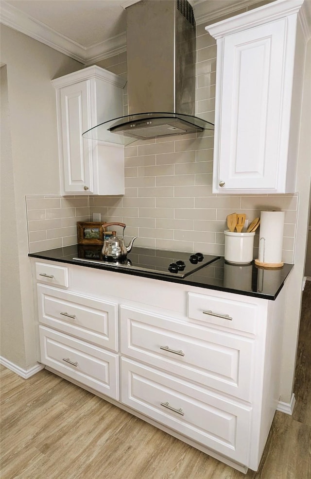 kitchen with dark countertops, wall chimney exhaust hood, and black electric cooktop