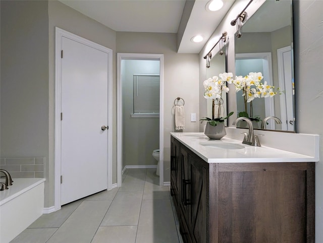 full bathroom with toilet, a sink, tile patterned flooring, double vanity, and baseboards