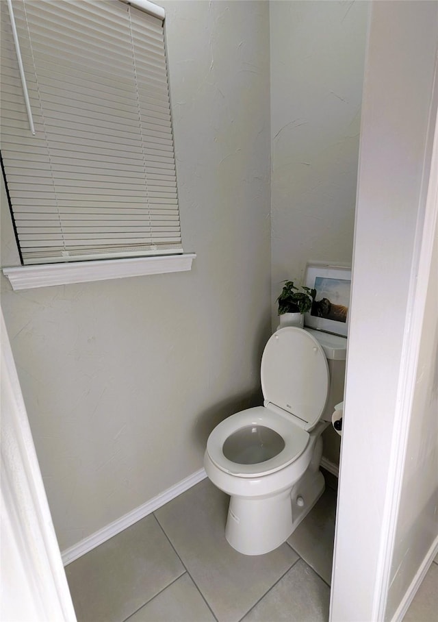 bathroom featuring tile patterned floors, toilet, and baseboards