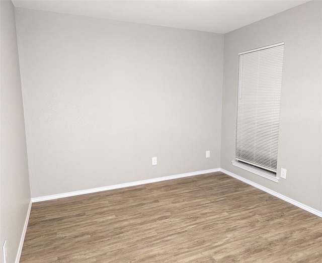 spare room with wood finished floors and baseboards