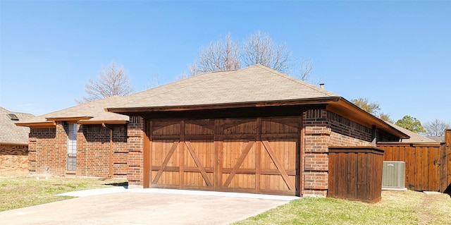 exterior space with brick siding, concrete driveway, an attached garage, and fence