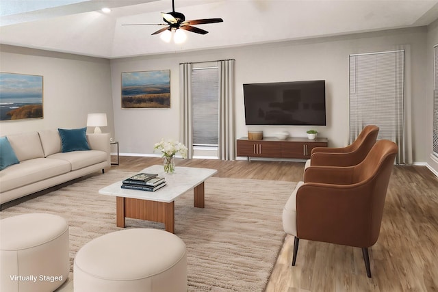 living area featuring baseboards, lofted ceiling, ceiling fan, and wood finished floors