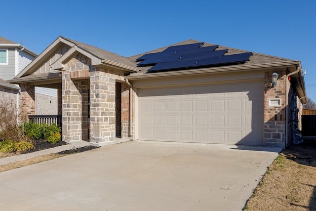 ranch-style home with brick siding, solar panels, and concrete driveway