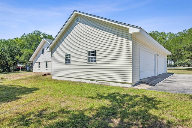 view of side of property with crawl space, a lawn, and a detached garage