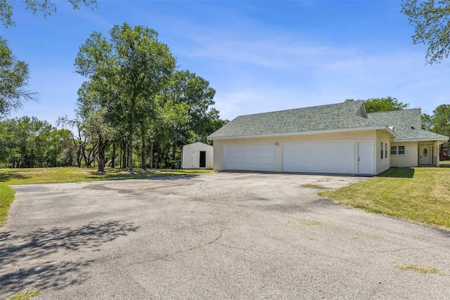 view of property exterior with driveway, a lawn, a garage, and roof with shingles